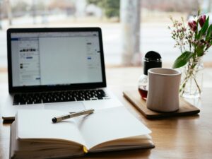Peaceful workspace with an open notebook, laptop, and coffee mug symbolizing balance, reflection, and support through Ace Partners